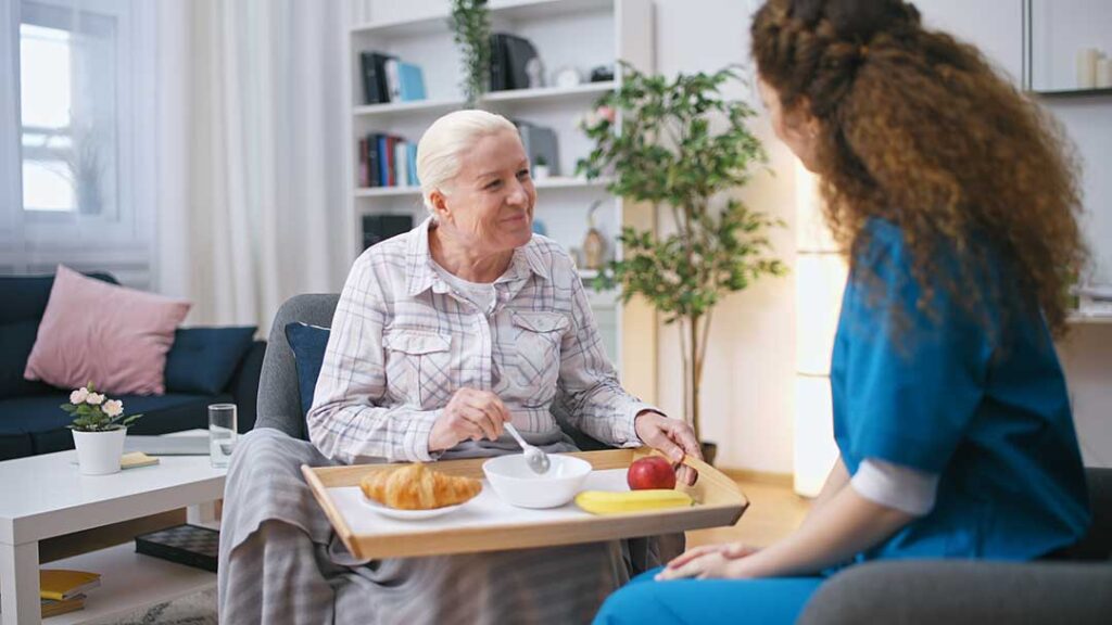 Adult child reviews a care plan with an older parent at a bright assisted living table.