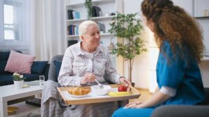 Adult child reviews a care plan with an older parent at a bright assisted living table.